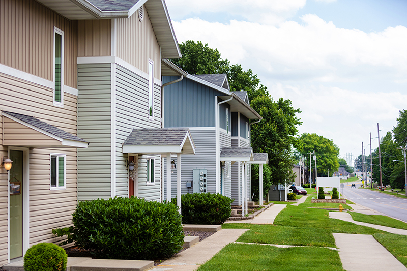 Groups of Townhouse Apartments with Healthy Green Yards on a Sunny Summer Day